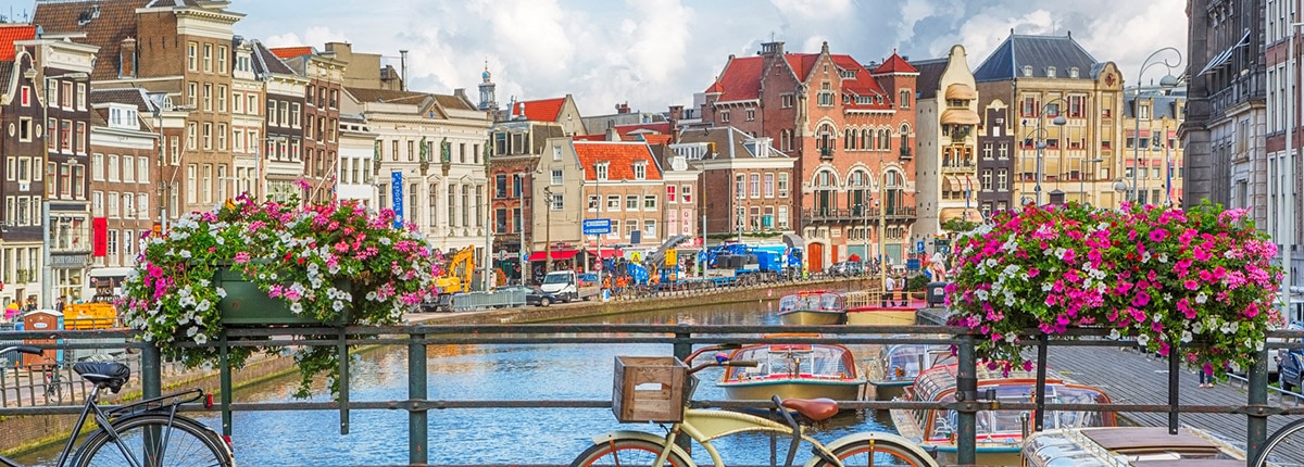 bicycles on a bridge over a canal with colorful buildings