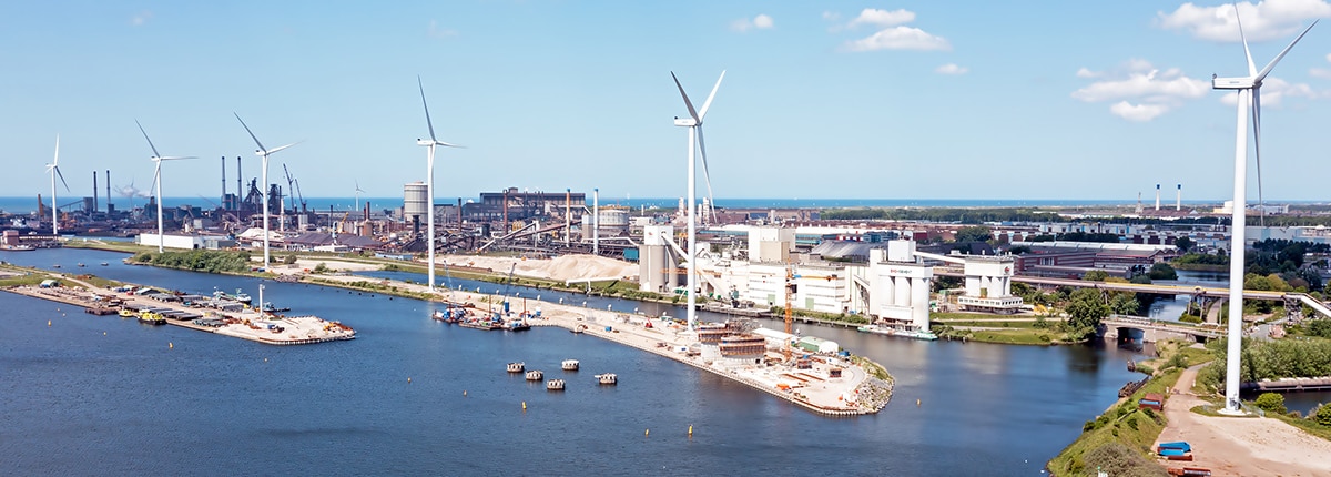 aerial view of windmills outside of a industrial harbor in ijmuiden