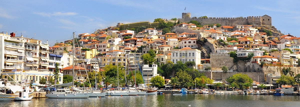 buildings with orange roofs are located on a mountainside of kavala