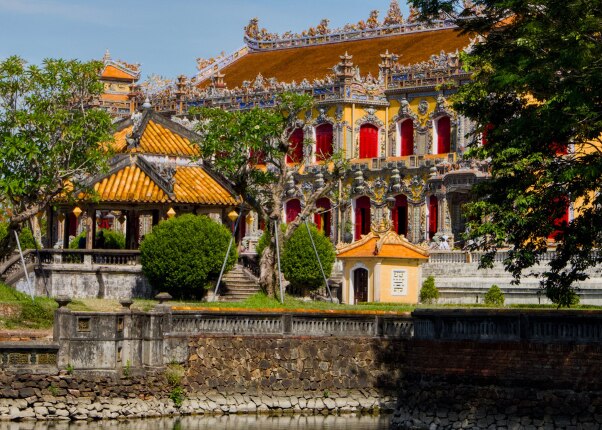 historic palace in vietnam featuring ornate architecture, gardens, and trees