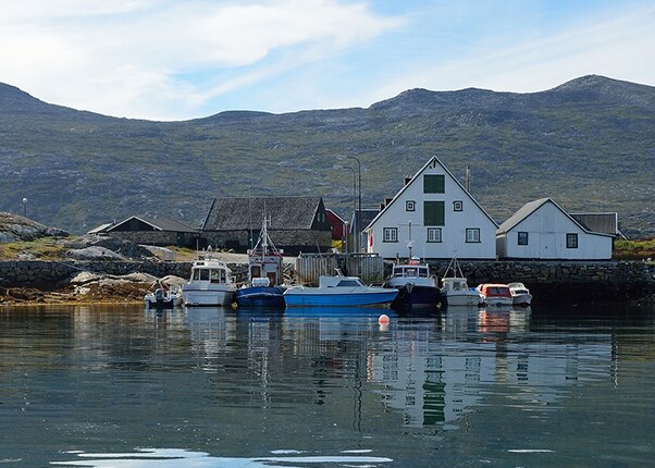 colorful houses and boats on a lake in nanortalik, greenland