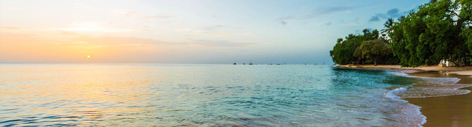 Sun setting while the gentle waves lap the beach in Barbados