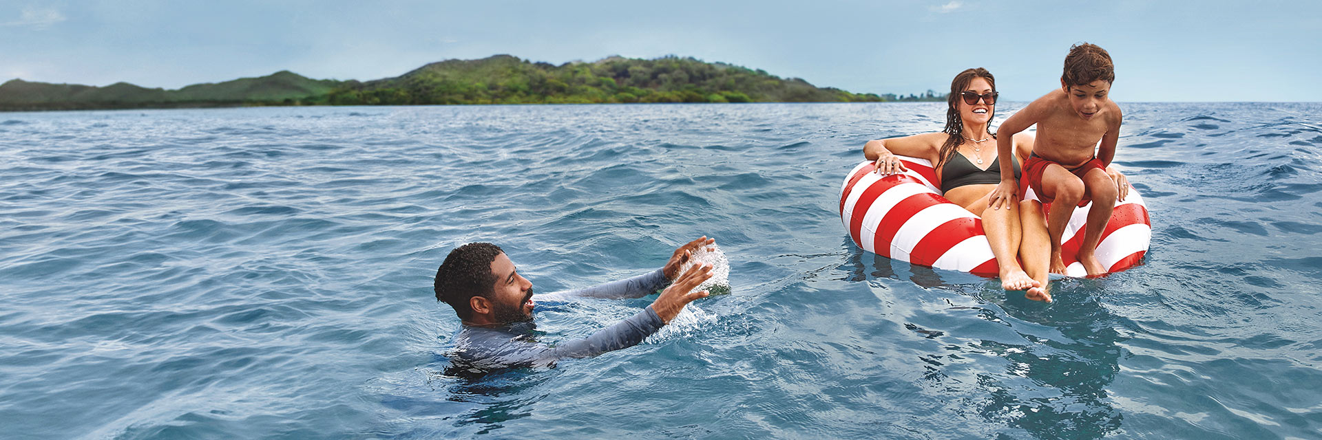 a family of three swims in the sea