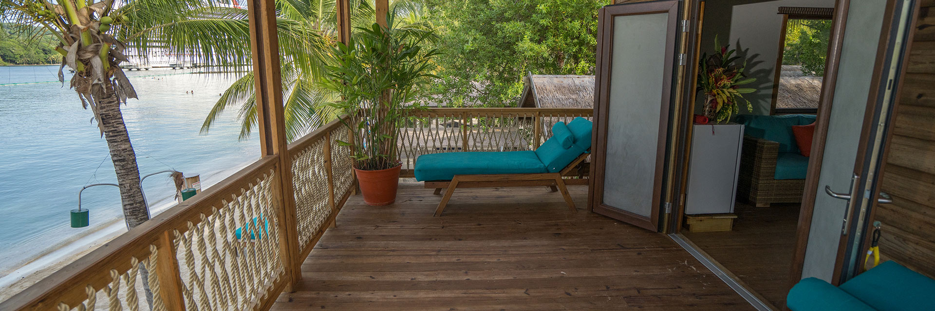 a lounge chair is located outside of a beach cabin