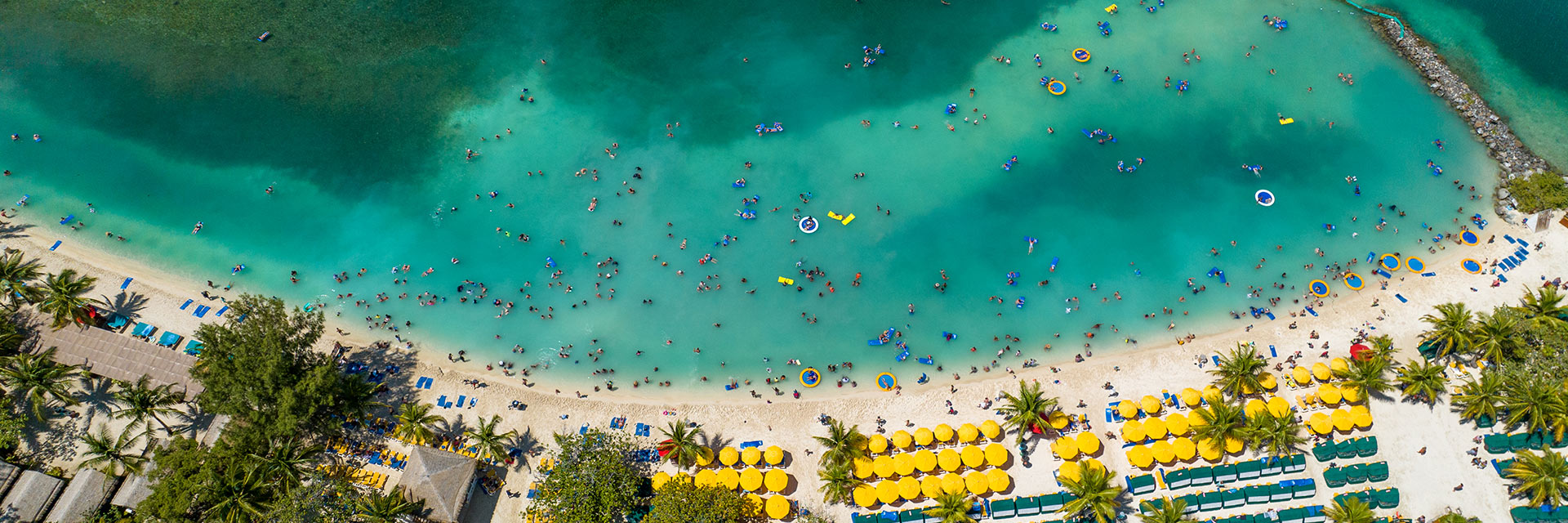an aerial view of guests swimming off the coast of the beach