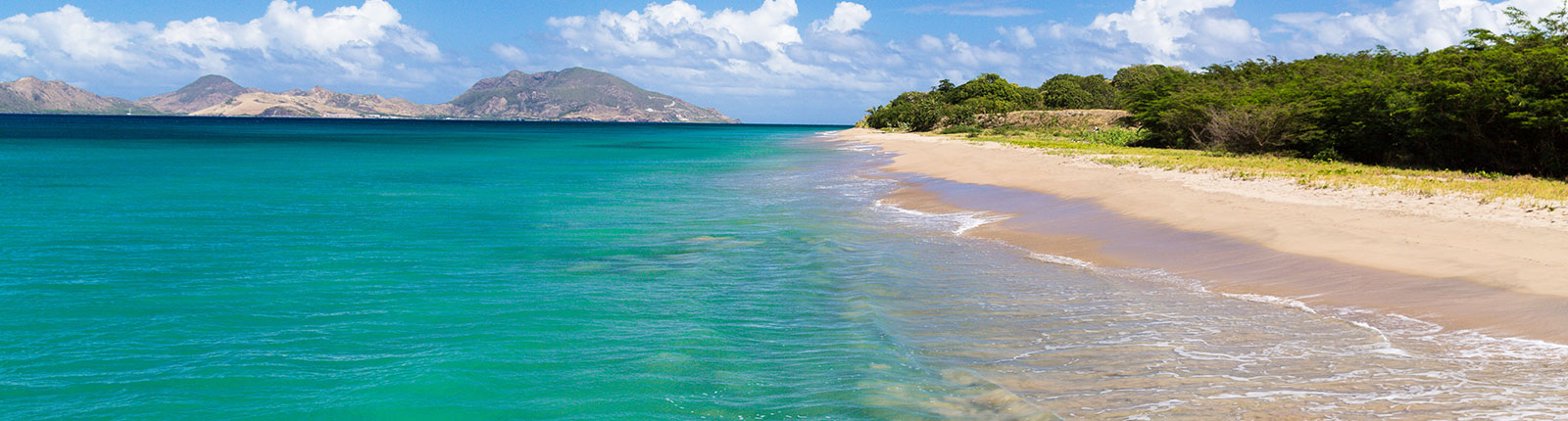 View of the gentle waves lapping an isolated beach in St. Kitts