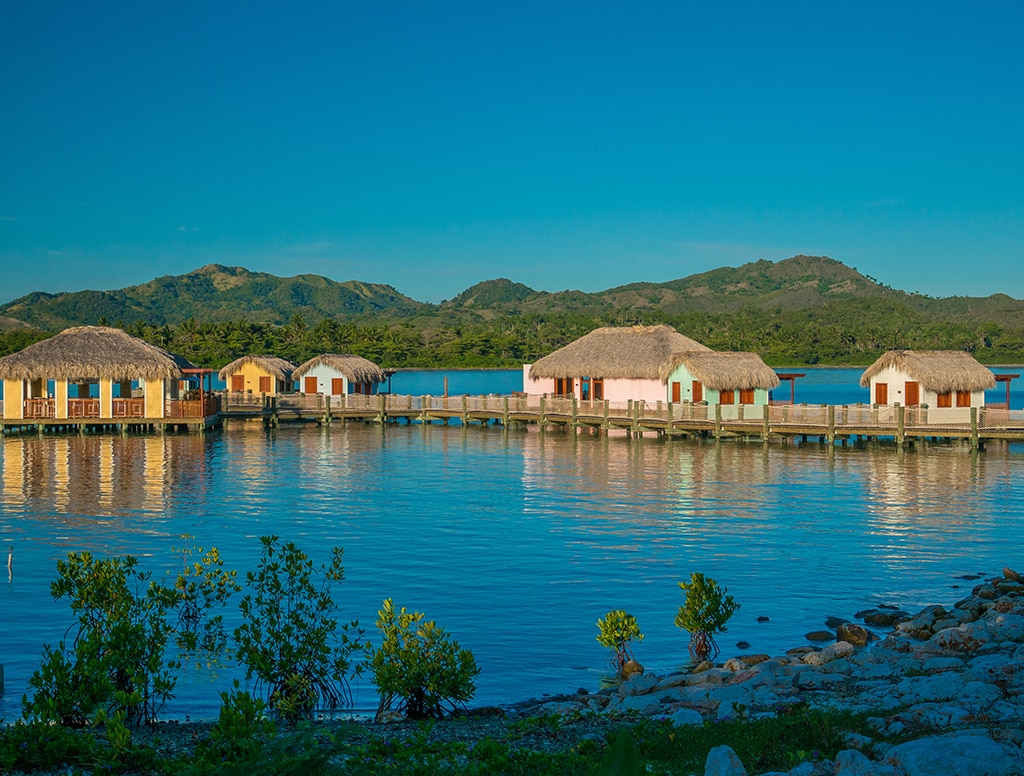 scenic view of tiki huts on the water in Amber Cove. 