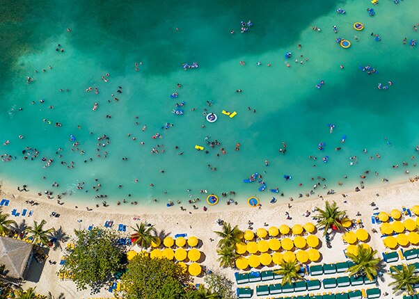 an aerial view of guests swimming off the coast of the beach