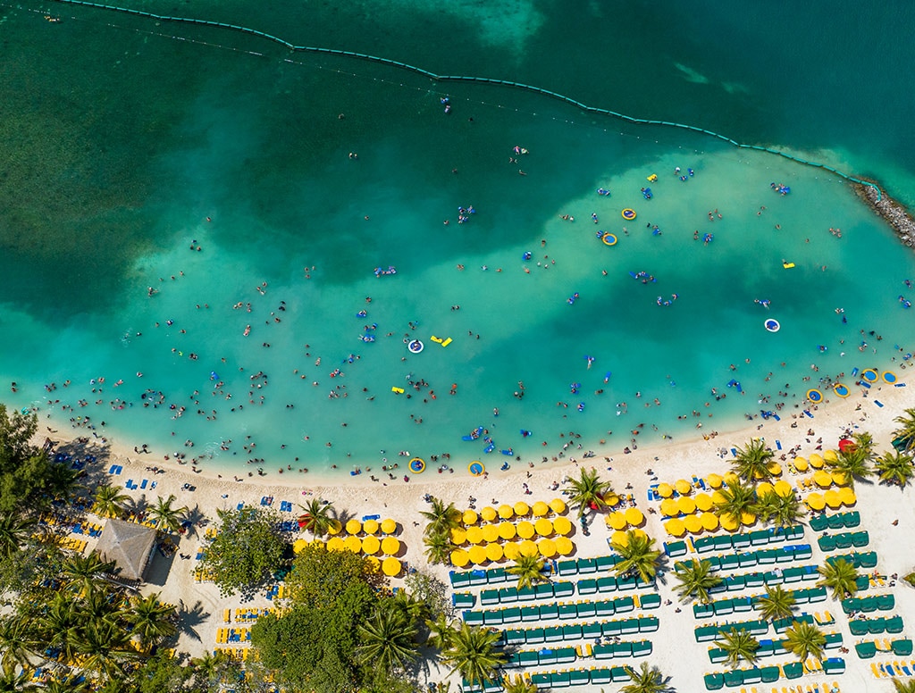 an aerial view of guests swimming off the coast of the beach
