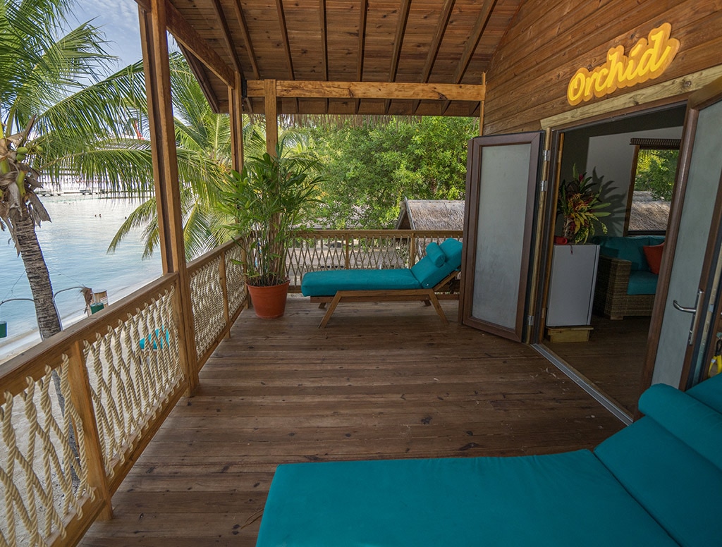 a lounge chair is located outside of a beach cabin