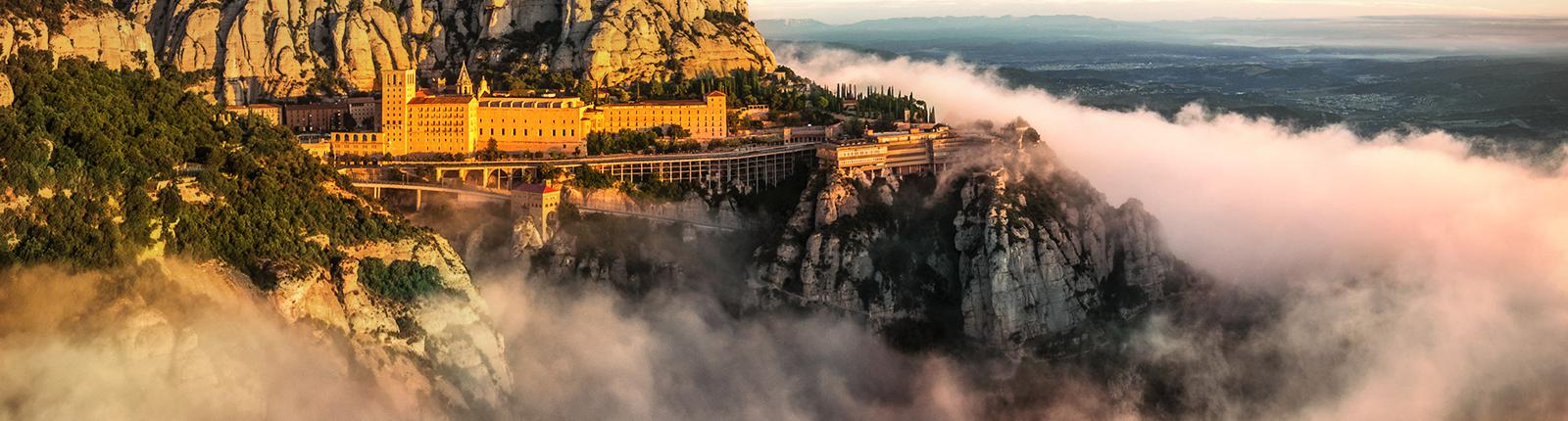 Santa Maria de Montserrat jutting out of the clouds in Barcelona, Spain