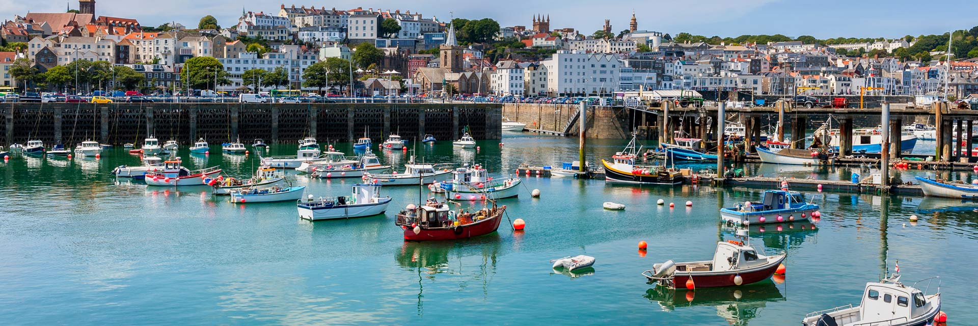 fising boats line the coast of st peter port
