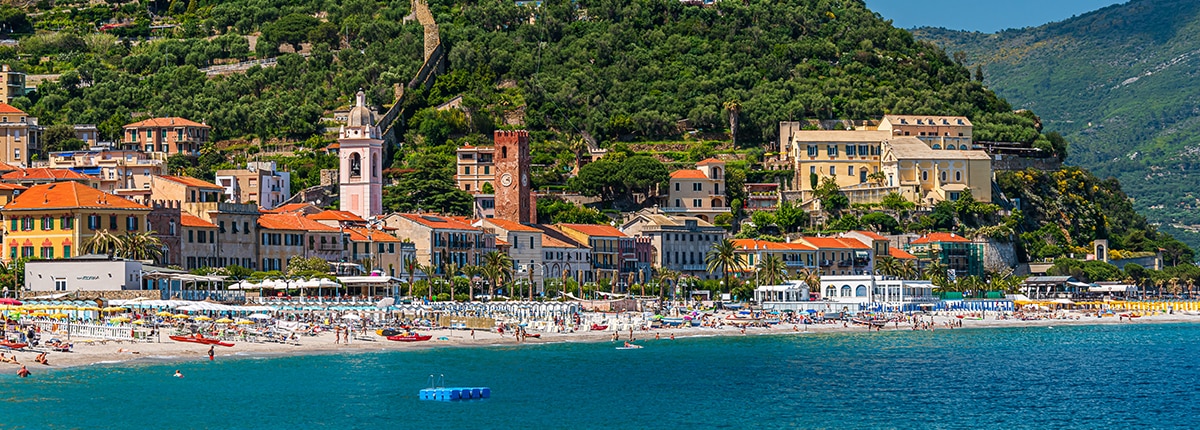 coastline and town in savona with mountains in the background