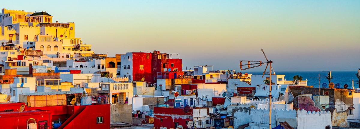 image of colorful buildings in tangier with the ocean in the background