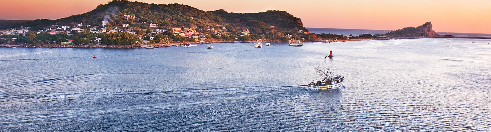 A lonely sailboat sailing through the clear waters of Mazatlan, Mexico