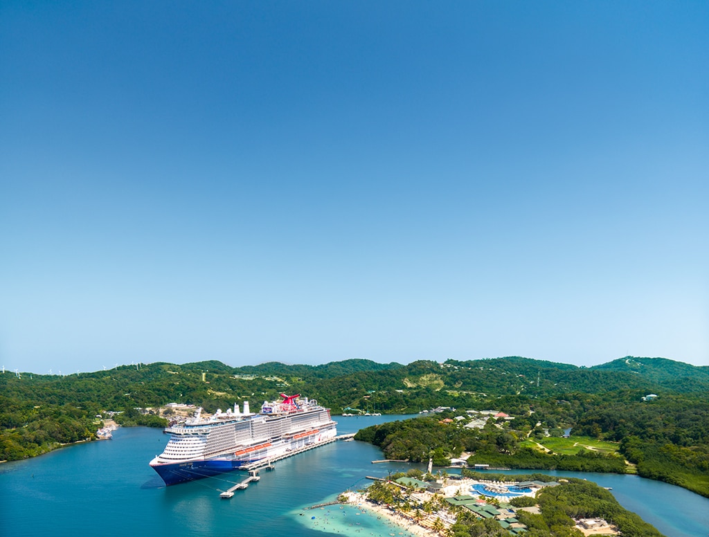 view of a carnival ship docked at isla tropicale roatan