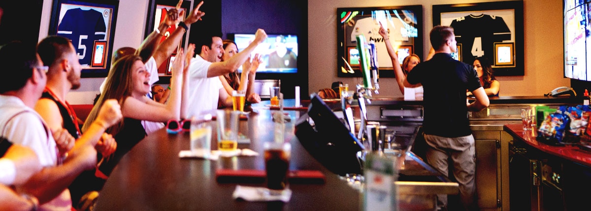guests cheering at carnival skybox sports bar