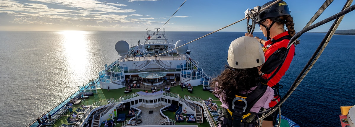 guest standing on the top deck preparing for her zipline adventure on a carnival cruise