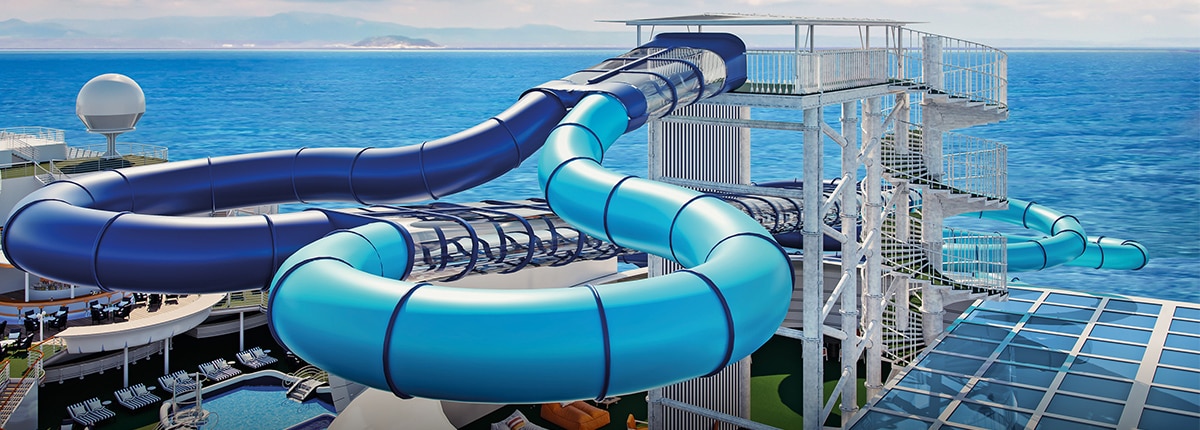 two blue waterslides are side by side with the ocean in the background