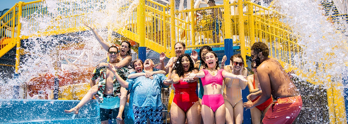 guests are splashed with with water at the carnival waterworks area onboard the ship