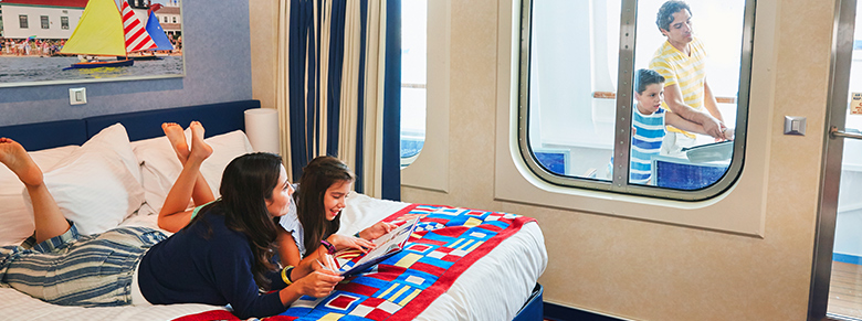 mom and daughter reading a magazine while dad and son relax on balcony