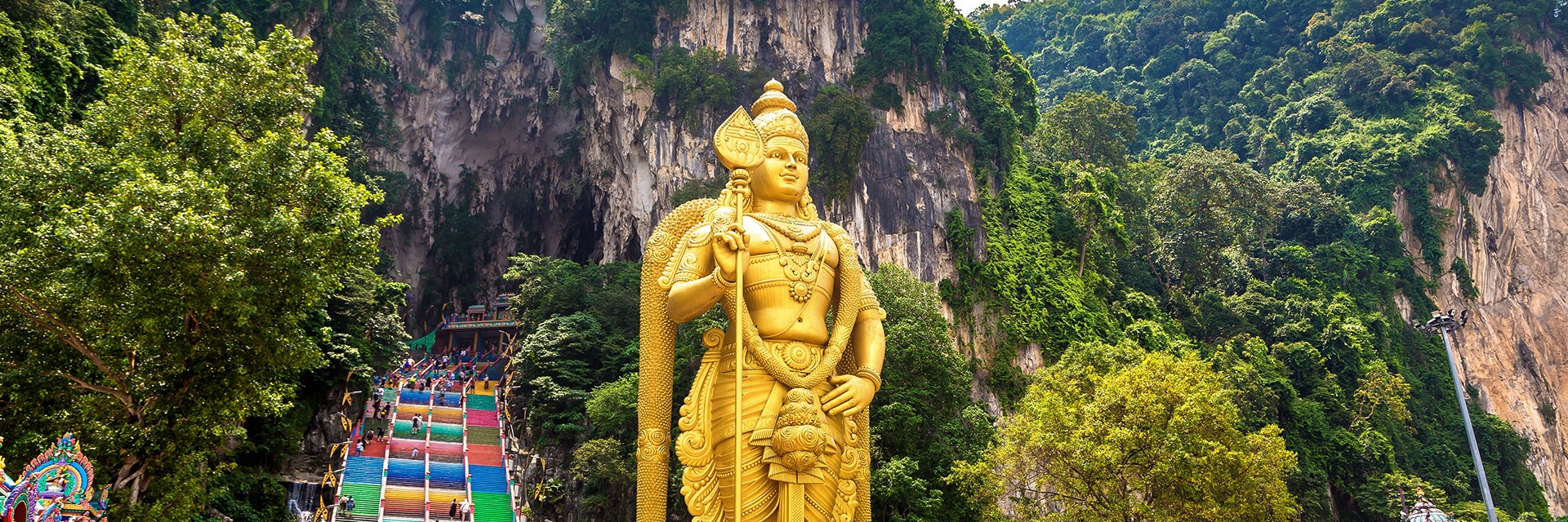 view of a statue in front of the entrance to the batu cave in port klang