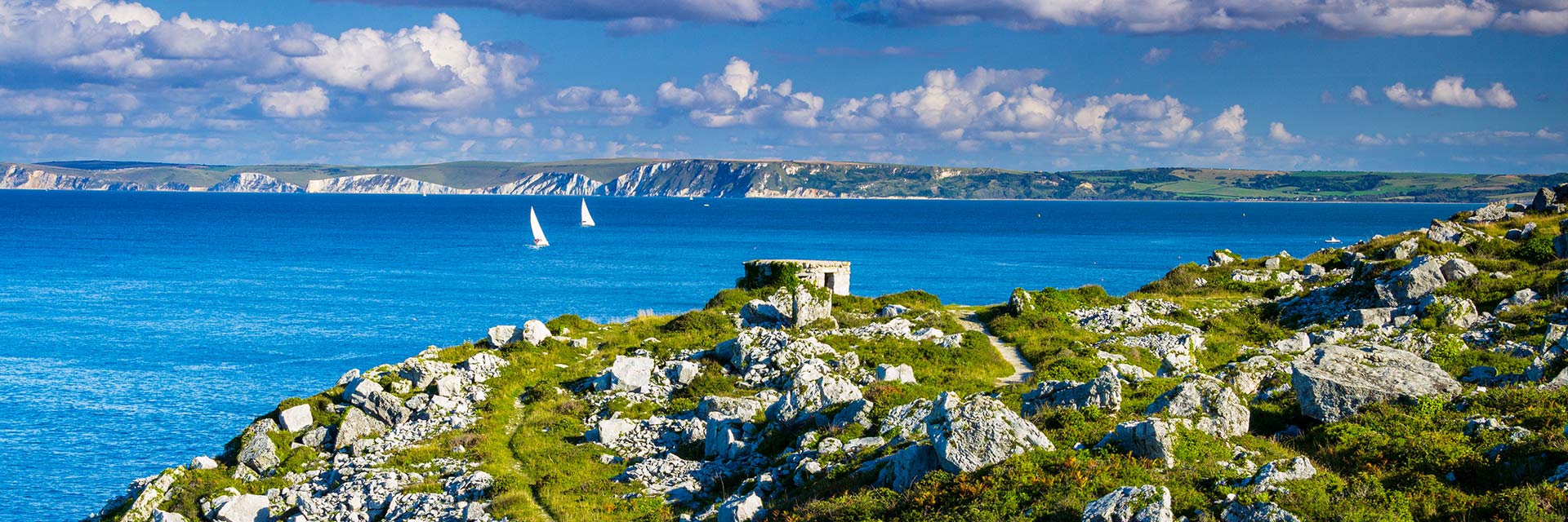 two sail boats sail off the coast of dorset