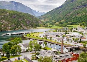a small town surrounded by a fjord, mountains and lush trees