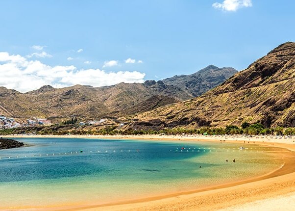 guests relax on the beach surrounded by mountains