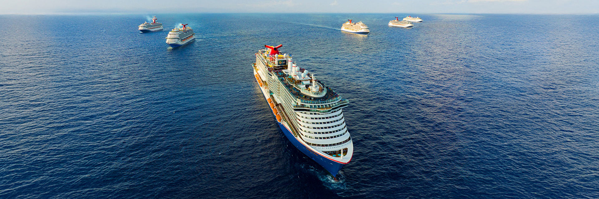 multiple carnival ships next to each other at sea