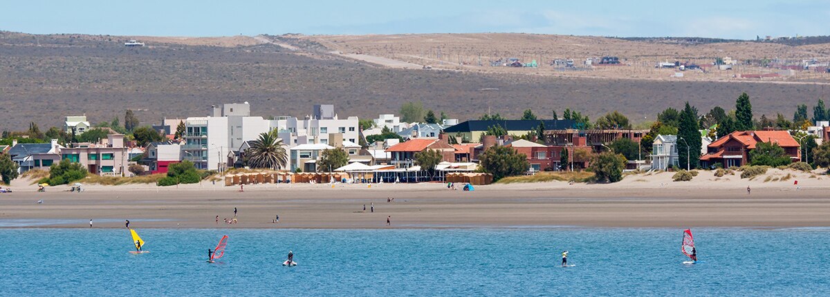 the bright coastline and windsurfers enjoying the waters in puerto madryn