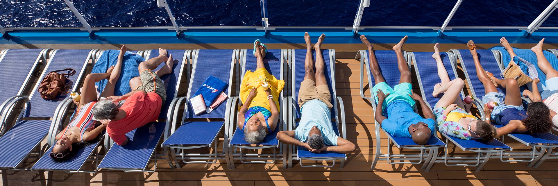 aerial view of guests lounging on pool chairs on the lido deck