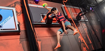kid playing basketball at sky zone on carnival panorama