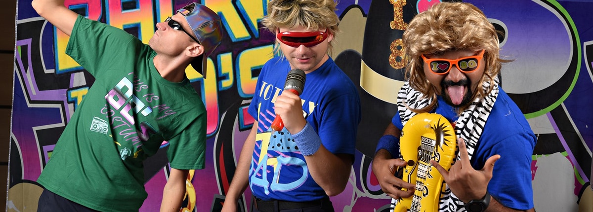 guests dressed in 80s attire and posing for a fun picture