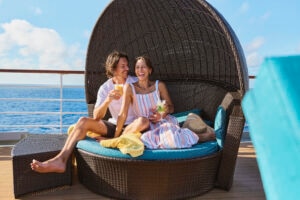 Young couple relaxing on a daybed on a cruise